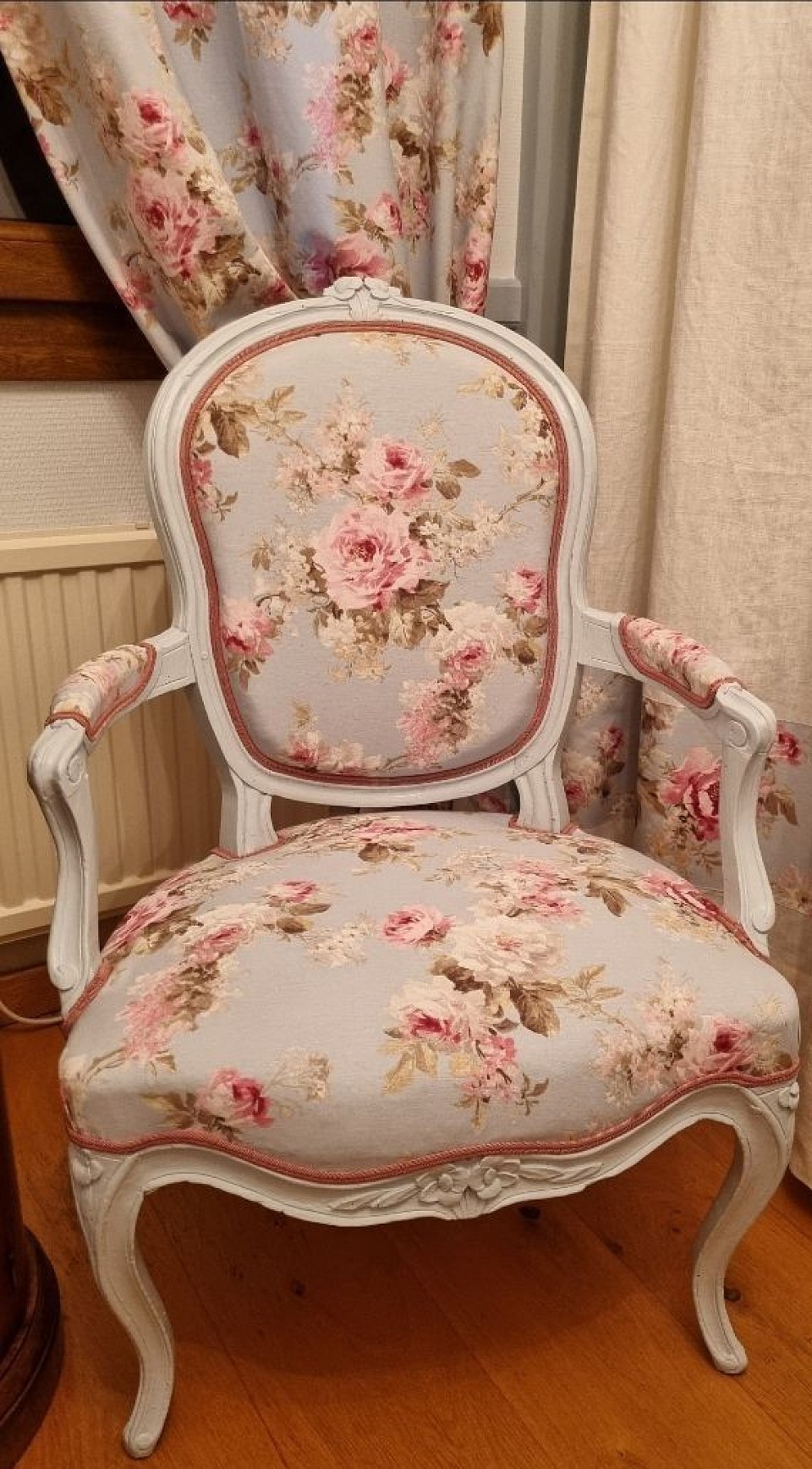 Fauteuil Louis XV restauré avec soin et recouvert d’un élégant tissu à fleurs — confort et charme d’origine retrouvés.